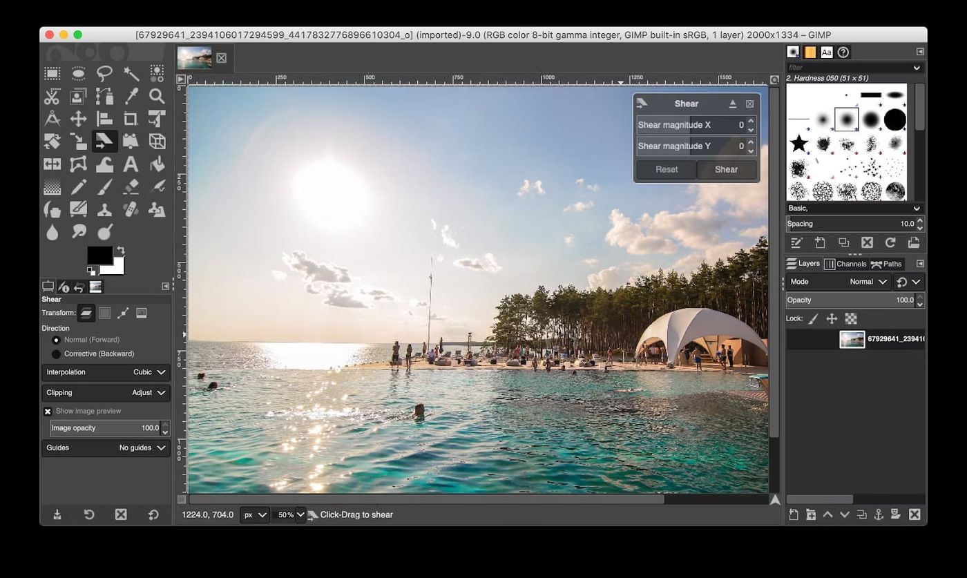 A landscape photo open in GIMP with its toolbox, layers panel, and a Shear transform dialog
